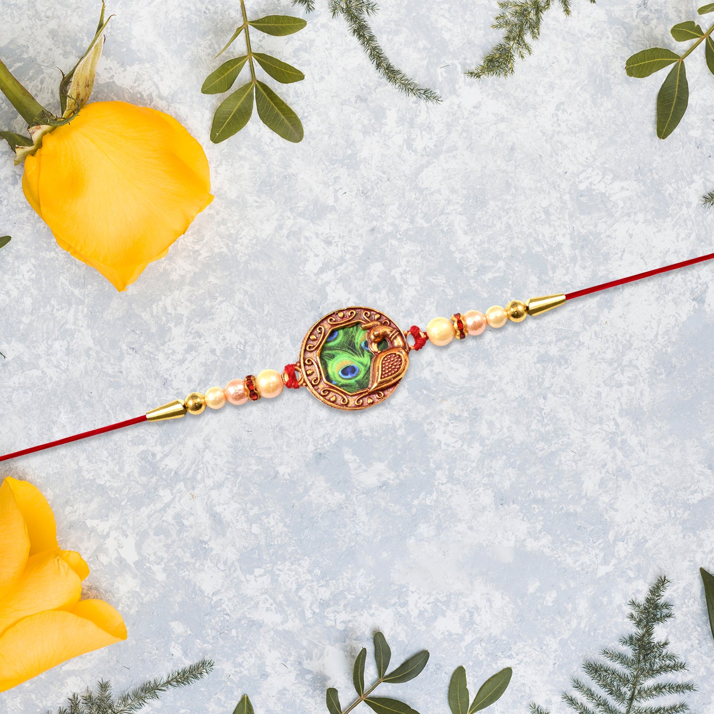 Elegant Rakhi With Peacock Feather Design And Pearl Bead Accents On Red Thread