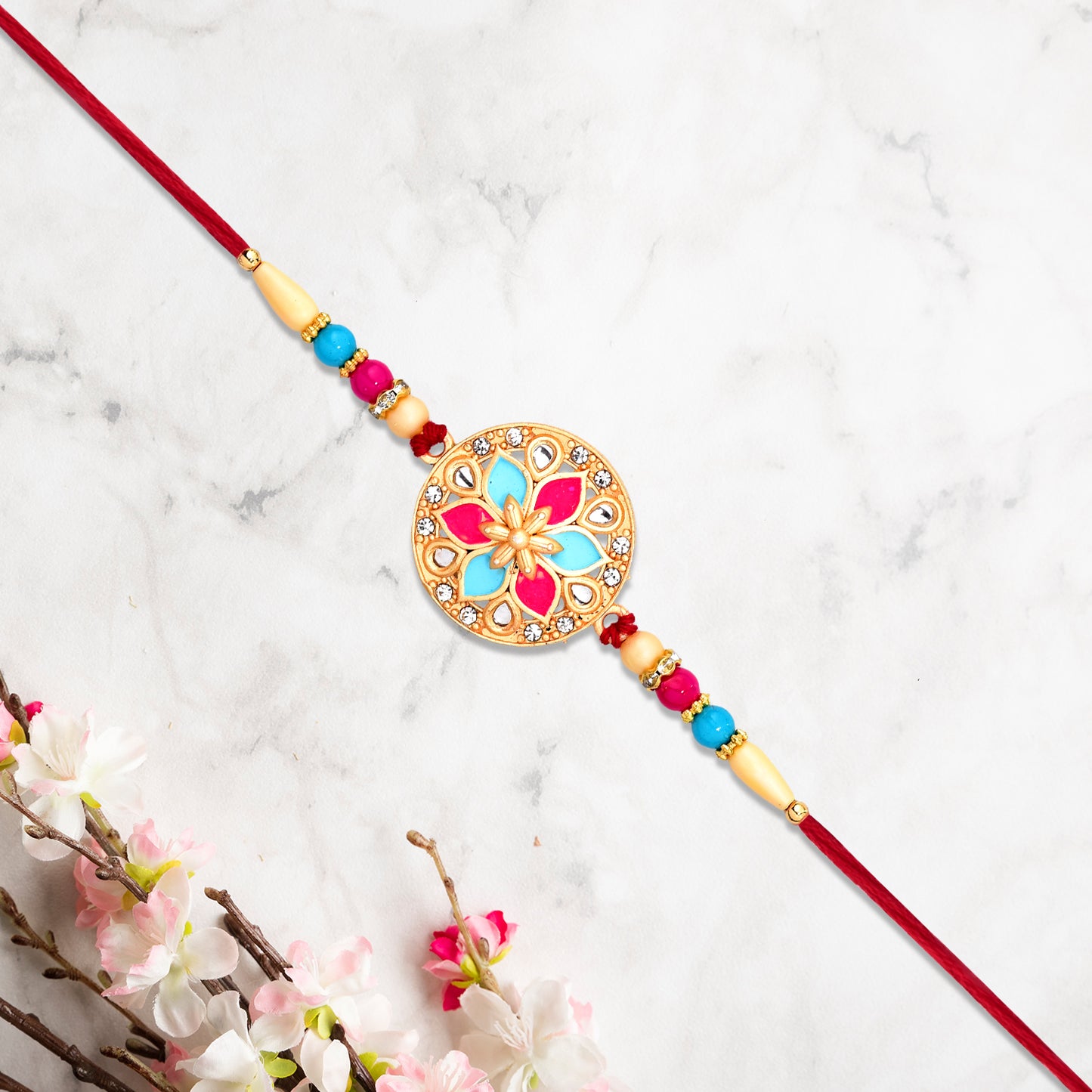 Round Floral Rakhi With Pink-blue Enamel And Beaded Thread